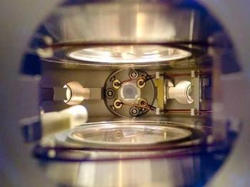 Ein tiefer Einblick in die Hauptvakuumkamer des NaK-Molekülexperiments. In der Mitte werden vier Hochspannungskupferdrähte zu einer Ultrahochvakuum-Glasküvette geführt, in der die ultrakalten polaren Moleküle erzeugt wurden.