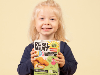 Kleines lachendes Kind mit Hühner Nuggets Verpackung
